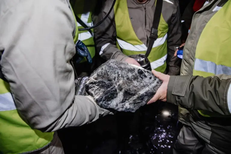 Представители Ассоциации «СТАННУМ» передают символический кусок оловянной руды на первом учредительном собрании в мае 2025 года, знаменуя развитие оловодобычи в России.