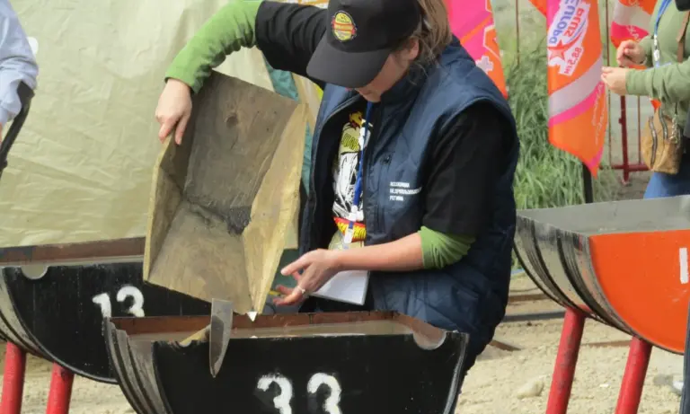 Участница промывает золотосодержащий песок в полубочке на фестивале «Старательский фарт»