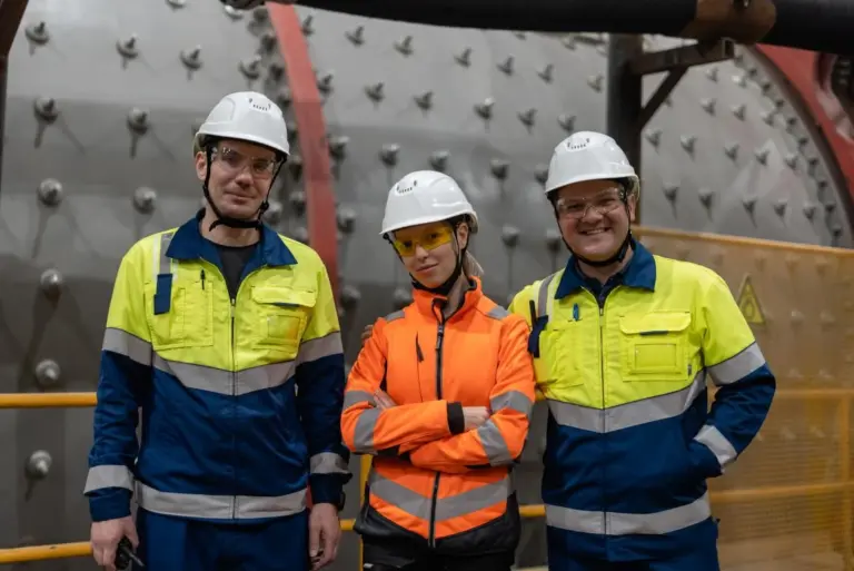 Сотрудники Хайлэнд Голд в спецодежде и касках на производстве. Открыты вакансии для специалистов на предприятиях компании в Камчатском и Забайкальском краях. Работа в золотодобывающей отрасли с возможностью профессионального развития.