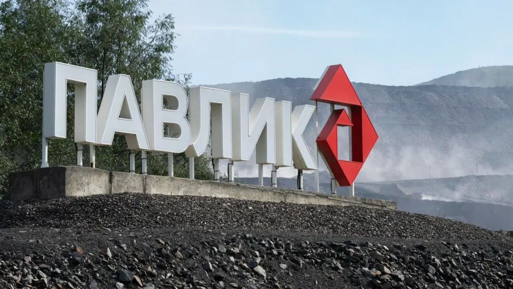 Логотипы компаний «Аурум», «Павлик» и ЮГК на фоне золотых слитков